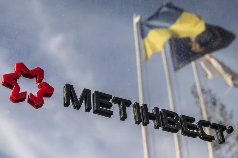 Logo koncernu Rinata Achmetowa z flagą ukraińską w tle fot. Bloomberg