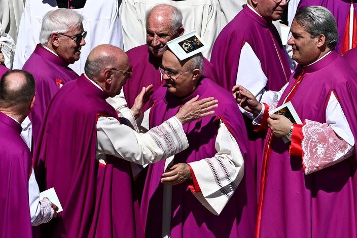 Duchowni przekazują sobie znak pokoju podczas mszy żałobnej za papieża Franciszka na placu św. Piotra w Watykanie, 26 kwietnia 2025 r.