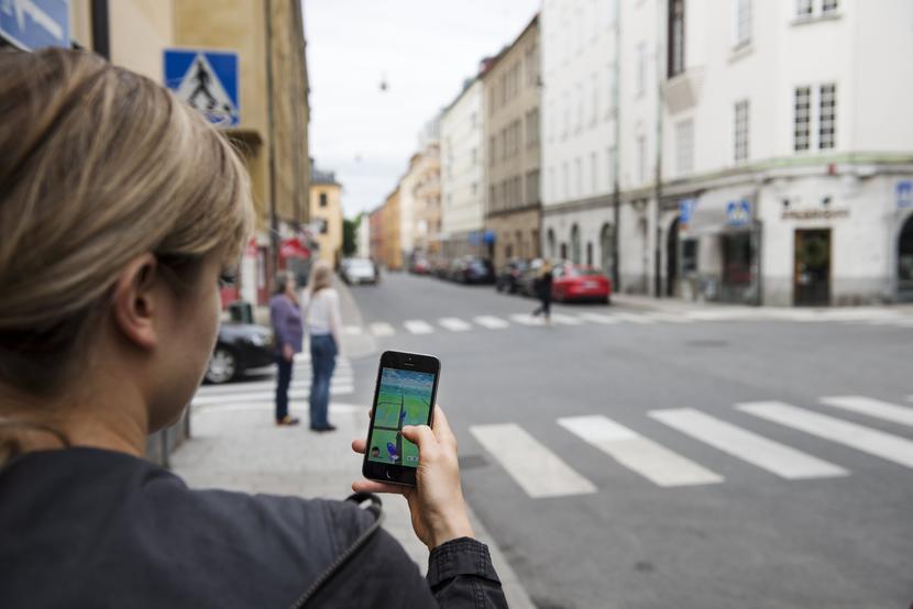 Kobieta grająca w Pokemon Go na ulicach Sztokholmu