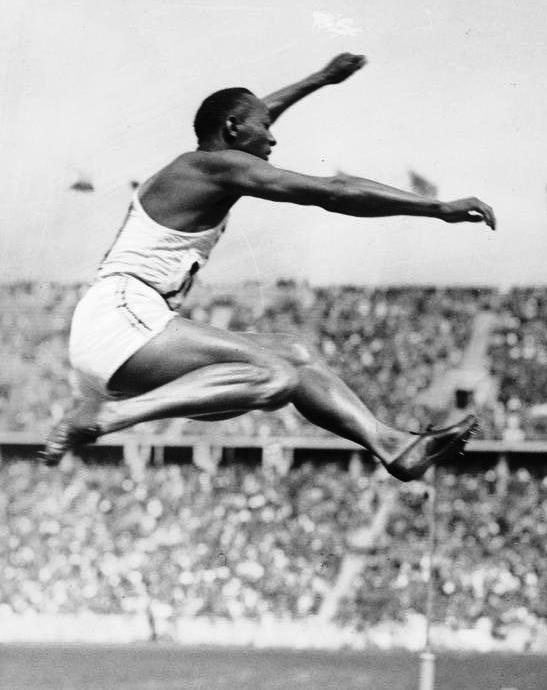 Jesse Owens w trakcie zwycięskiego skoku w dal.