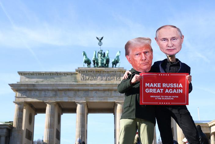 Ludzie w maskach przedstawiających prezydenta USA Donalda Trumpa i prezydenta Rosji Władimira Putina pozują do zdjęć podczas protestu pod Bramą Brandenburską w Berlinie, Niemcy, 20 lutego 2025 r.