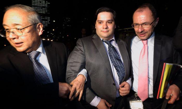 Mark Karpelès eskortowany w piątek z sądu w Tokio, prezes Mt. Gox, fot. Bloomberg