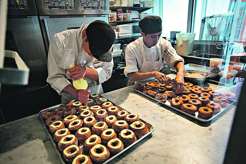 POPYT I PODAŻ: Cronut to cukiernicza krzyżówka donuta z croissantem, napełniona waniliowym kremem,
 obtoczona w cukrze klonowym i polana różanym lukrem. Nowojorska piekarnia piecze ich tylko 250 dziennie,
 więc kolejki ustawiają się już przed świtem. [FOTT. BLOOMBERG]