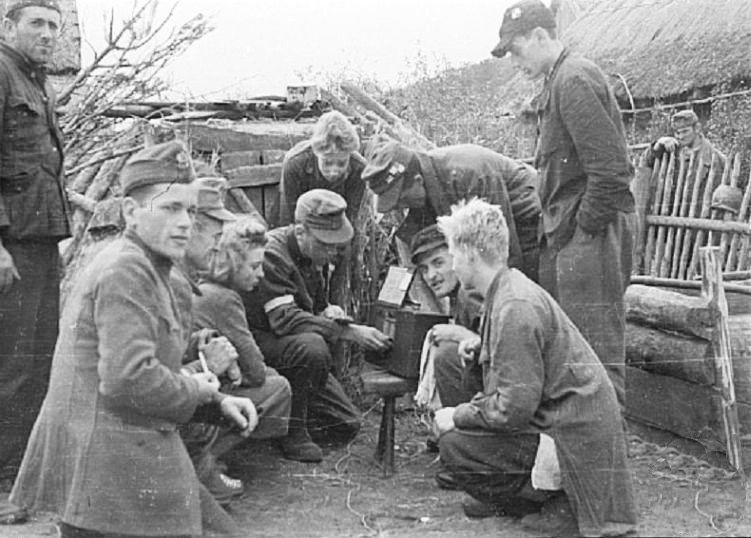 Żołnierze Kompanii Lotniczej Grupy Kampinos słuchają audycji Błyskawicy, we wsi Wiersze, około 15 września 1944