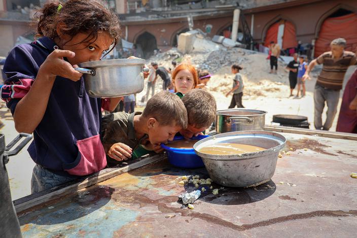 Palestyńskie dzieci piją zupę rozdawaną przez organizację charytatywną wśród gruzów Gazy, 16 sierpnia 2025 r. Mieszkańcy miasta zmagają się z poważnymi niedoborami żywności w związku z blokadą i izraelskimi atakami.