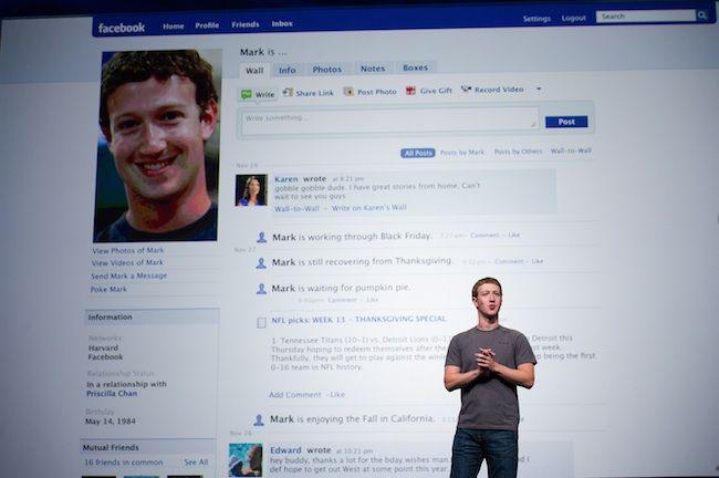 Mark Zuckerberg na tle swojego profilu na Facebooku fot. Bloomberg