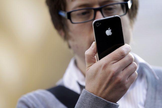 Mężczyzna trzyma iPhone'a (fot. Bloomberg)