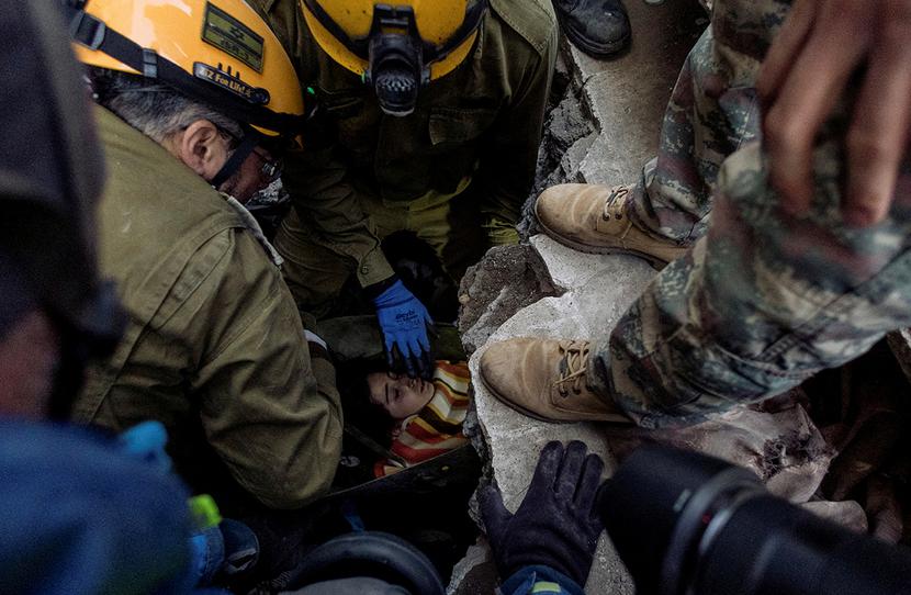 Kahramanmaras, Turcja, 9 lutego 2023 r. Członkowie izraelskich sił zbrojnych i tureckiej ekipy ratowniczej wyciągają spod gruzów 14-latkę uratowaną po trzęsieniu ziemi.