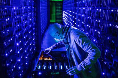 Pracownik w masce ochronnej przeprowadza inspekcję procesorów graficznych (GPU) firmy Sapphire Technology Ltd. na farmie kryptowalut Evobits w rumuńskim mieście Kluż-Napoka w środę 22 stycznia 2020 r. Druga najcenniejsza kryptowaluta na świecie, Ethereum, zyskała w tym roku 75 proc., wyprzedzając większego rywala Bitcoina.