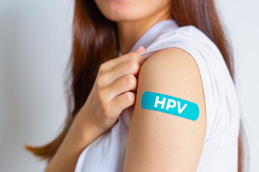 HPV (Human Papillomavirus) Teenager woman showing off an blue bandage after receiving the HPV vaccine.viruses Some strains infect genitals and can cause cervical cancer. Woman health concept. HPV (Human Papillomavirus) Teenager woman showing off an blue bandage after receiving the HPV vaccine.viruses Some strains infect genitals and can cause cervical cancer. Woman health concept.